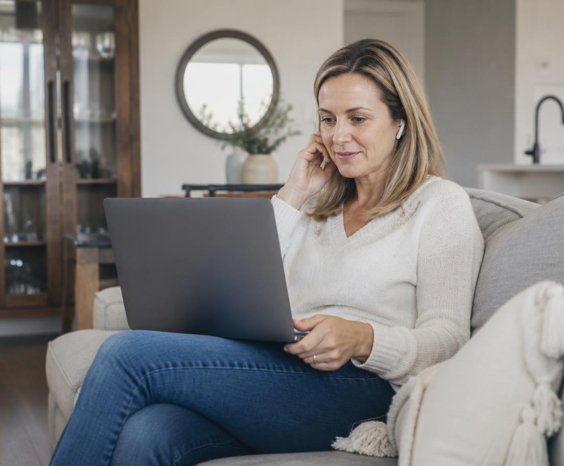 A woman at home taking a video call from her sofa